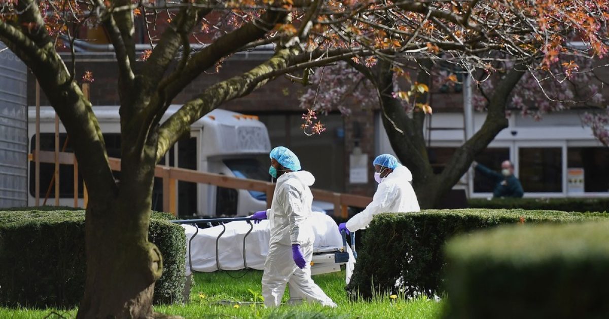 Funcionários transportam corpo de vítima do coronavírus no Kingsbrook Jewish Medical Center, em Nova York, na quarta-feira (8) — Foto: Angela Weiss/AFP