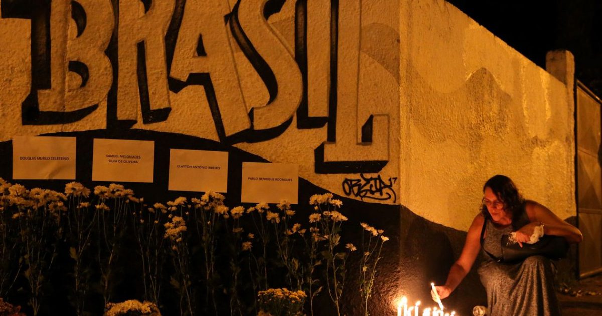 Uma mulher acende velas durante homenagem às vítimas do tiroteio na escola Raul Brasil em Suzano, São Paulo. REUTERS/Amanda Perobelli