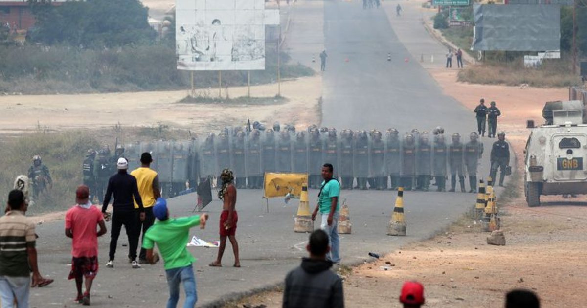 Pessoas atiram pedras em membros da guarda nacional venezuelana, na fronteira, visto de Pacaraima, Brasil 24 de fevereiro de 2019. REUTERS / Ricardo Moraes