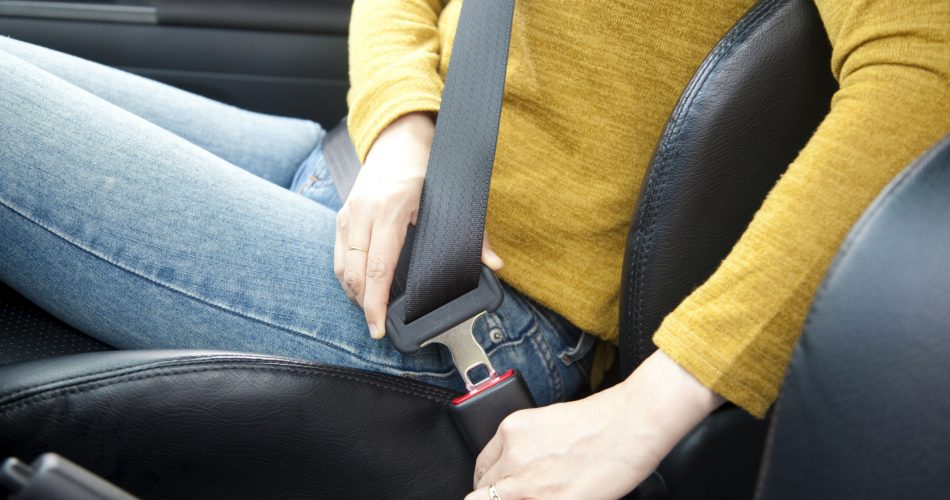 woman hand fastening a seat belt in the car