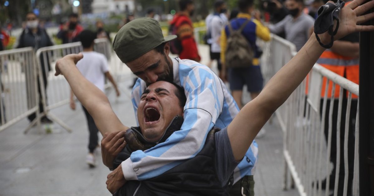 Argentino chora e é amparado pelo amigo na Plaza de Mayo, em frente à Casa Rosada, onde o corpo de Diego Maradona é velado — Foto: Rodrigo Abd/AP