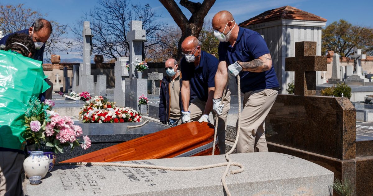 29 de março - Funcionários de uma funerária usam máscaras durante o enterro de uma vítima de coronavírus COVID-19 no cemitério de Fuencarral em Madri, na Espanha — Foto: Baldesca Samper/AFP